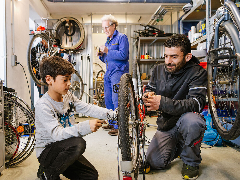 Ein Junge und ein Mann reparieren ein Fahrrad 