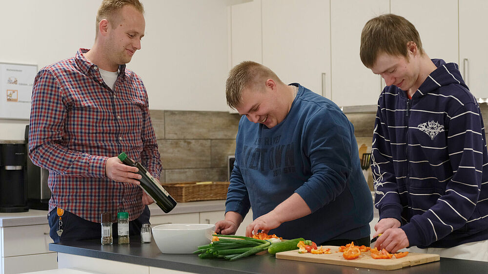 Mitarbeiter unterstützt Mieter beim Kochen 