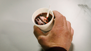 Auf dem Bild sieht man eine Hand mit einem Becher Tee.