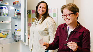 Eine Klientin und eine Mitarbeiterin am Kühlschrank