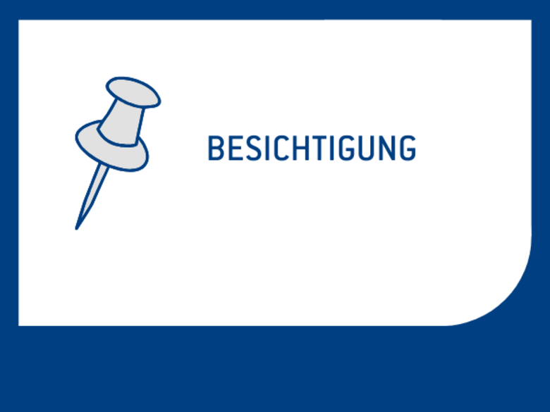 Eine Reißzwecke und das Wort "Besichtigung"